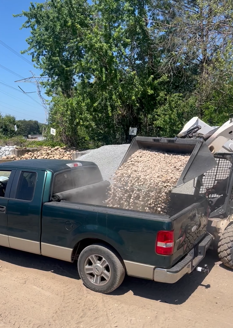 Galvao truck loaded with gravel from skid steer at the yard